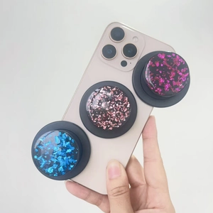 Three gold foil glitter MagSafe phone sockets in blue, pink, and purple on a smartphone