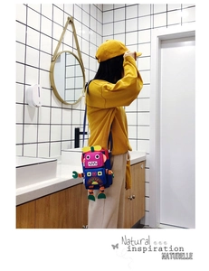 Sac à bandoulière robot porté par un mannequin avec des coutures colorées et fun