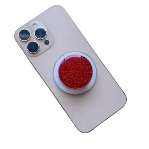 Close-up of red glitter resin magnetic phone grip on a white smartphone back