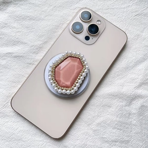 Detailed macro of pink crystal MagSafe phone grip with pearls and rhinestones on back