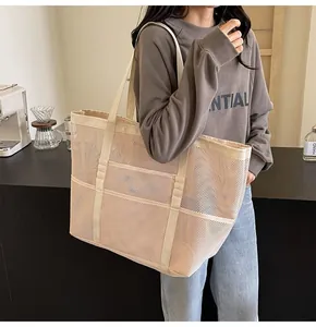 Detail of mesh tote bag showing reinforced handles and functional outer pockets