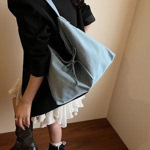 Light blue large capacity tote bag with drawstring bows and letter design on model