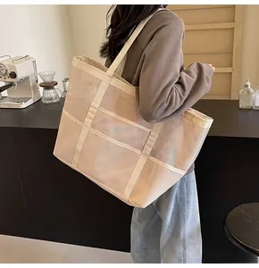 Close-up of beige mesh tote bag with breathable hollow weave and reinforced handles