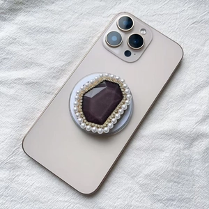 Detail of luxury Magsafe phone grip with purple crystal, rhinestones and white pearls