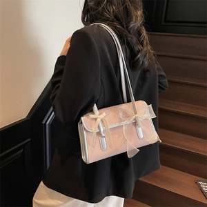 Borsa sottobraccio rosa con fiocco in tulle, mostrata su una modella in ambiente moderno
