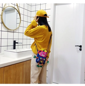 Bandoulière réglable sur un adorable mini sac de robot porté par un mannequin chic