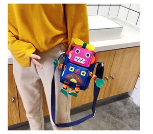 Détail d'un sac bandoulière coloré en forme de robot avec pièces 3D et sangle large