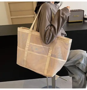 Close-up of beige mesh tote bag showing breathable hollow texture and sturdy straps