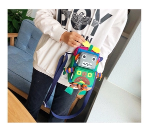 Détail du sac bandoulière robot coloré montrant le patchwork de tissu et les membres en 3D
