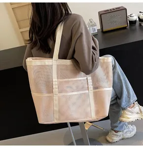 Detail of large capacity mesh tote bag in beige with wide canvas shoulder straps
