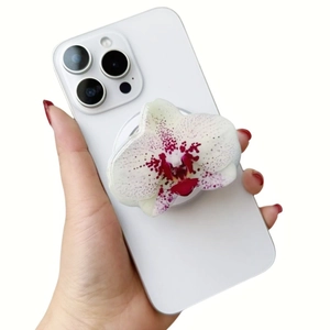 Detailed view of pink orchid acrylic magnetic phone grip on a white smartphone