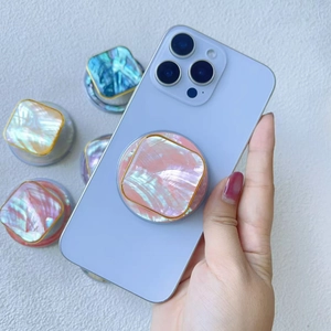 Detail of shimmering pink shell phone grip with gold frame and assorted colors