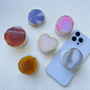 Détail de supports de téléphone en agate et pierre naturelle avec bordure dorée