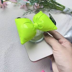 Neon green padded bow magnetic phone grip holder on white smartphone with glossy finish