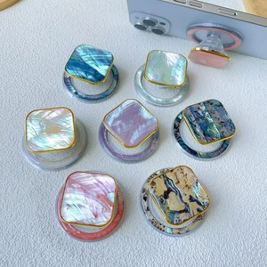 Detailed close-up of square shell texture phone grips with gold frames and glossy finish
