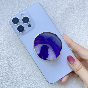 Gros plan d'un support de téléphone en agate violette avec bordure dorée sur smartphone