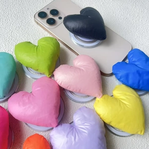 Macro view of colorful heart-shaped puffy fabric phone grips with soft texture