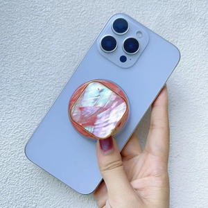 Detailed view of square iridescent shell phone stand with gold rim on smartphone