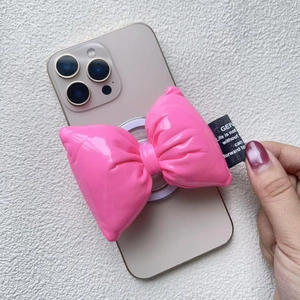 Macro detail of glossy pink bow magnetic phone grip with padded leather texture