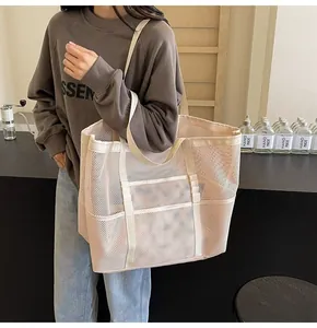 Detail of a beige mesh tote bag showing the semi-transparent texture and wide shoulder strap