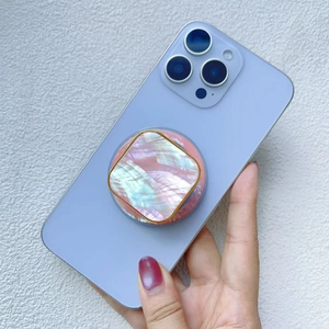 Macro shot of colorful shell texture phone grip with gold frame on blue smartphone
