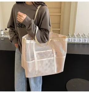 Detailed view of beige mesh tote bag with front pockets on a minimalist cafe background
