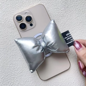 Macro detail of silver bow magnetic phone grip with metallic texture and woven label