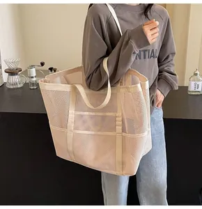 Detail of beige mesh tote bag featuring breathable hollow design and external mesh pockets