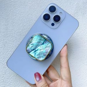 Detail shot of a telescopic phone grip with colorful shell texture and gold metal frame