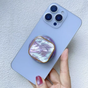 Detail of square phone socket with purple marble shell texture and gold trim on blue phone