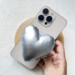 Detail of silver metallic fabric heart phone stand with telescopic grip on smartphone