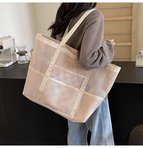Rear view of model wearing a large mesh tote bag in a casual cafe setting