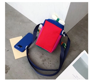 Détail du sac bandoulière en toile multicolore avec un accessoire d'hélice ludique
