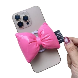 Pink puffy bow magnetic phone socket holder on smartphone with stylish fabric tag