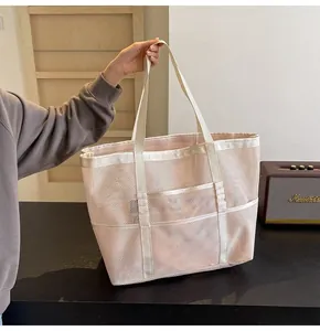 Close-up of pink mesh beach tote showing breathable net fabric and front pocket