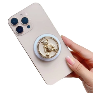 Detail of 3D bear phone grip with gold metallic edge on pink smartphone