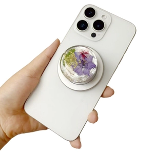 Detail of floral resin magnetic phone grip with real dried flowers on a smartphone