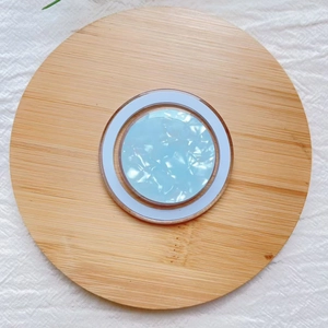 Close-up of a blue shell pattern MagSafe phone grip on a natural bamboo tray