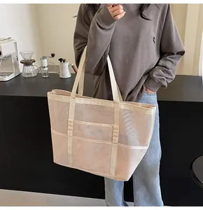 Close-up of cream mesh tote bag with canvas handles in a cozy cafe lifestyle setting