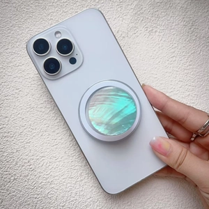 Detailed view of round magnetic phone socket with iridescent green shell texture inlay
