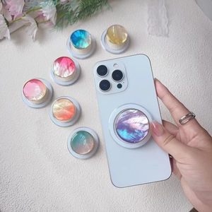 Detail showing various iridescent shell texture phone grips with metallic gold borders