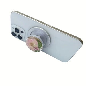 Macro shot of silver-plated magnetic phone grip featuring real pink dried flowers
