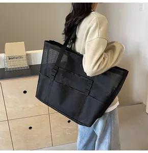 Detailed side view of large black mesh tote bag showing spacious capacity and daisy chain straps