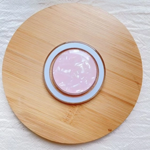 Close-up of pink marble texture MagSafe phone grip on a minimalist wooden tray