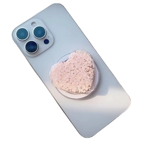 Pink glitter heart phone grip and Magsafe kickstand on light blue smartphone back