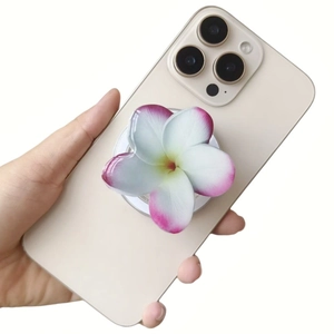 Detail showing hand holding Frangipani acrylic phone holder for MagSafe with pink gradient