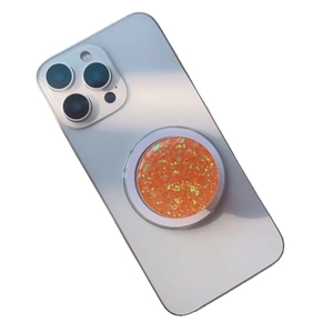 Magnetic glitter resin phone socket with orange sequins on a white smartphone