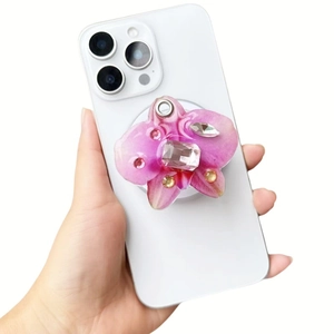 Macro detail of orchid phone grip with gradient pink resin and luxury crystals on white phone