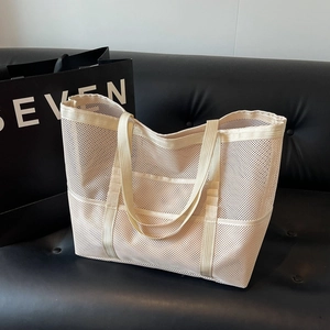 Minimalist beige mesh tote bag with exterior pocket for beach and summer travel