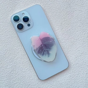 Detail of pink leaf phone grip with acrylic drip glue finish on a blue smartphone